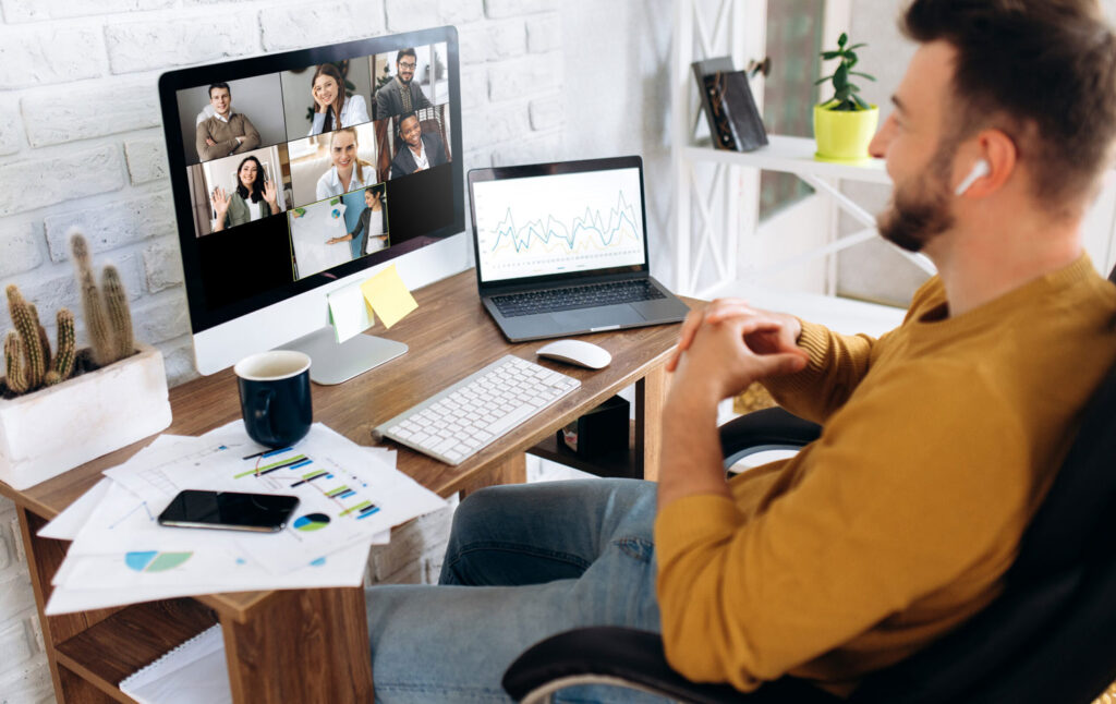 person looking at a computer screen with a video conference on it